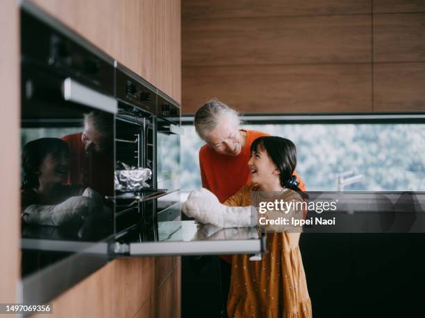 grandmother and granddaughter cooking together - melbourne food stock pictures, royalty-free photos & images