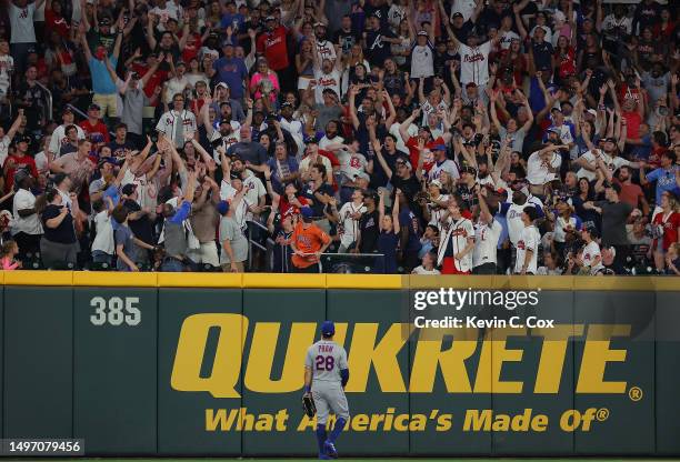 Tommy Pham of the New York Mets watches as fans try to catch the game-tying solo homer hit by Orlando Arcia of the Atlanta Braves in the ninth inning...