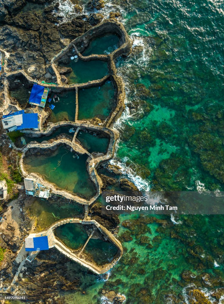 Unique concrete pools along the shore, used to bring tidal water up and down into the pools to raise seafood, Phu Quy island, Binh Thuan province