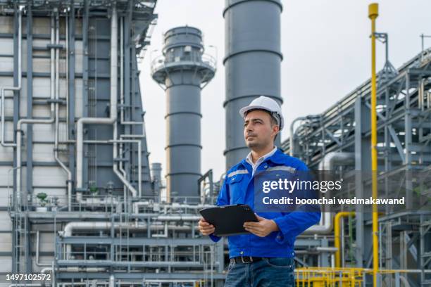 engineer with digital tablet working at petroleum oil refinery, and power plant. - petrokemisk fabrik bildbanksfoton och bilder