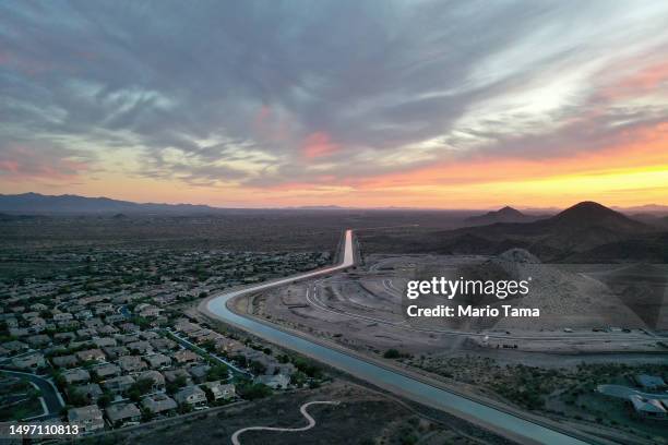 In an aerial view, the Central Arizona Project canal runs past homes and new home construction in the Phoenix suburbs on June 8, 2023 in Peoria,...