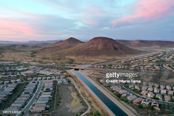 In an aerial view, the Central Arizona Project canal runs past homes in the Phoenix suburbs on June 8, 2023 in Peoria, Arizona. The project carries...