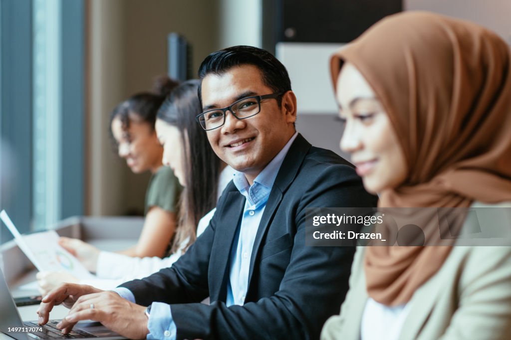 Diverse business people in modern office. Mature serious businessman in suit working in large office