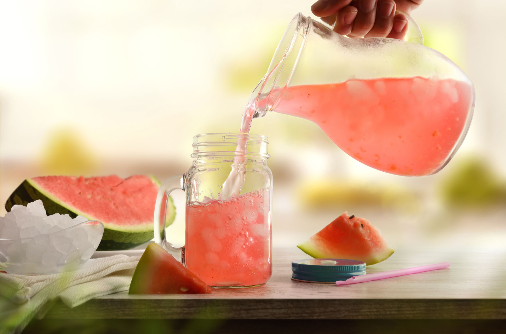 Person serving freshly prepared refreshing watermelon drink on kitchen bench Person serving freshly prepared refreshing watermelon drink on kitchen bench