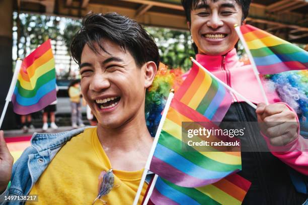 young asian gay couple during pride parade - person of colour stock pictures, royalty-free photos & images