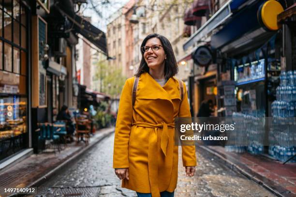 mujer joven caminando por las calles de estambul - mirar alrededor fotografías e imágenes de stock
