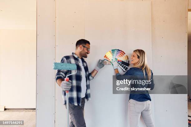 welche farbe sollten wir für unsere wand wählen? - couple painting stock-fotos und bilder