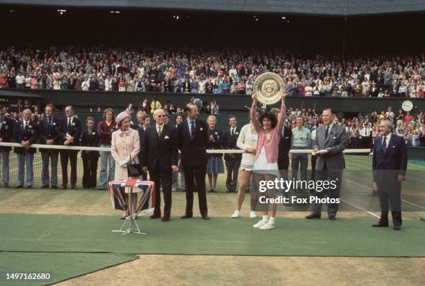 British tennis player Virginia Wade holds the winners trophy in the presence of Queen Elizabeth II and the Duke of Kent after wining the Women's...