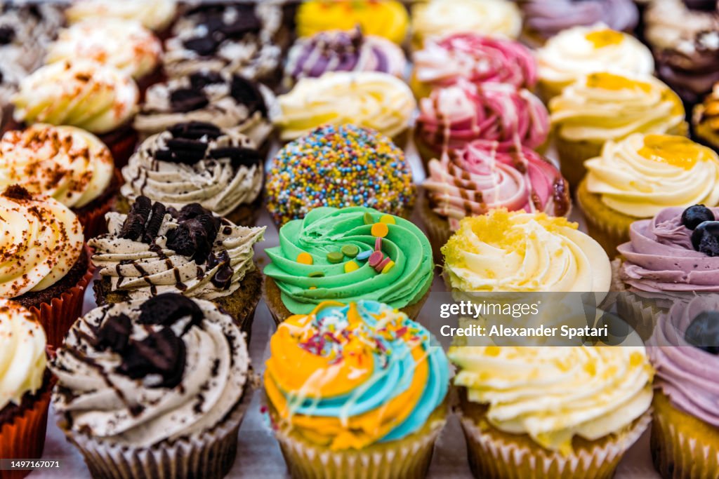 Multi-colored vibrant cupcakes for sale at the bakery