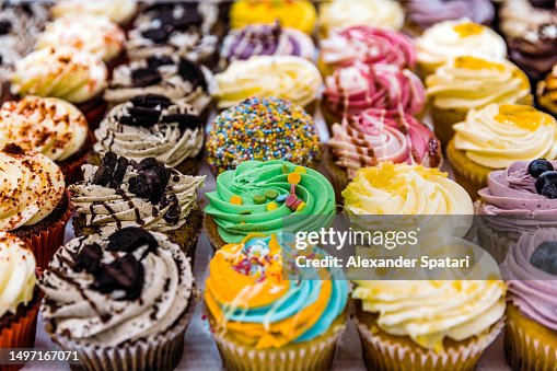Multi-colored vibrant cupcakes for sale at the bakery Multi-colored vibrant cupcakes for sale at the bakery