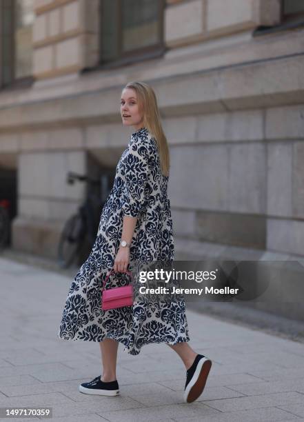 Lil Paulin seen wearing a darkblue and white flower printed long dress, pink mini handbag, Emporio Armani brown big shades, Daniel Wellington silver...