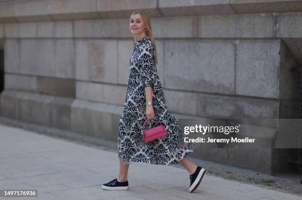 Lil Paulin seen wearing a darkblue and white flower printed long dress, pink mini handbag, Emporio Armani brown big shades, Daniel Wellington silver...