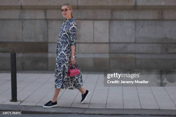 Lil Paulin seen wearing a darkblue and white flower printed long dress, pink mini handbag, Emporio Armani brown big shades, Daniel Wellington silver...