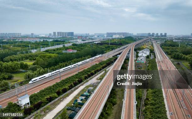 high-speed rail against urban skyline - china high speed rail stock pictures, royalty-free photos & images