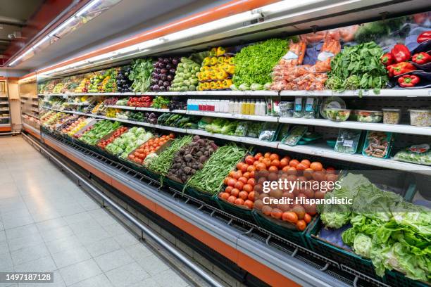 frisches gemüse im kühlregal des supermarktes - supermarktgang stock-fotos und bilder