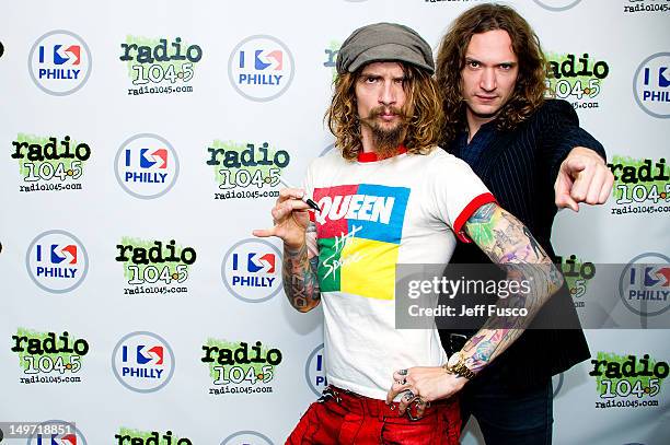 Justin Hawkins and Dan Hawkins of The Darkness pose at the Radio 104.5 iHeart Performance Theater on August 2, 2012 in Bala Cynwyd, Pennsylvania.