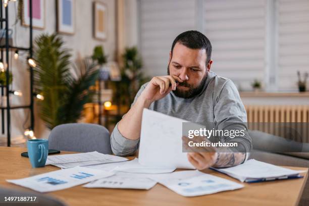 man checking personal finances at home - debt consolidation stock pictures, royalty-free photos & images