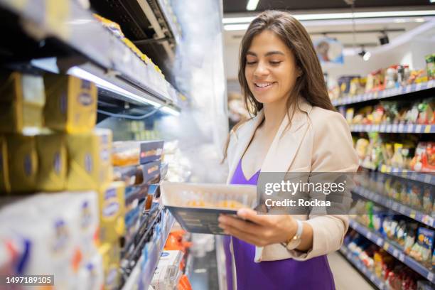 jeune femme dans un supermarché - ready meal photos et images de collection