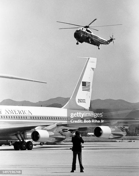 Marine One helicopter carrying U.S. President Ronald Reagan flies behind Tail number 26000 of Air Force One for landing at Point Mugu Naval Air...