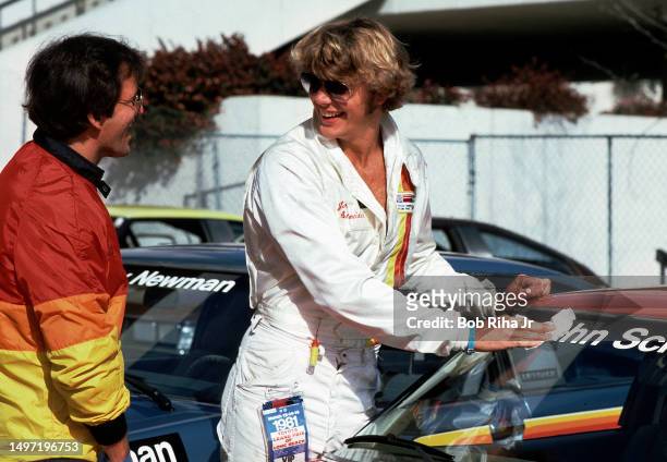 Actors Josh Taylor and John Schneider talk racing strategy prior to racing in celebrity race, March 14, 1981 in Long Beach, California.