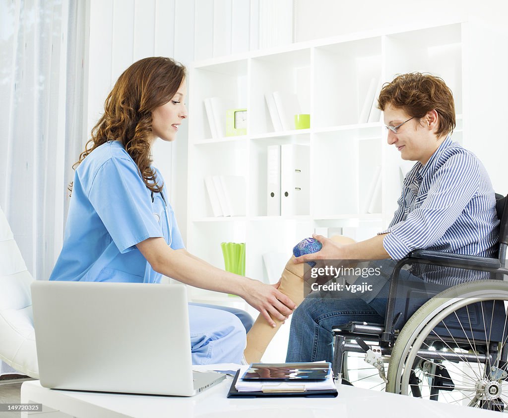 Behinderte Frau mit künstlichem Bein in Arzt-Büro.