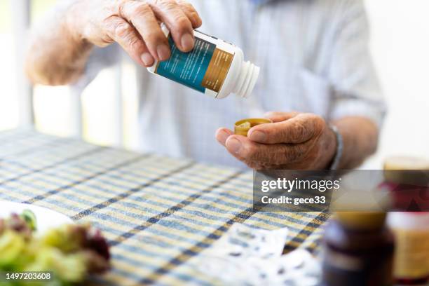 elderly man is getting vitamin pill - b stock pictures, royalty-free photos & images