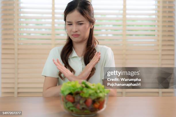 les femmes asiatiques n’aiment pas manger des salades vertes, elle s’ennuyait et n’aimait pas l’odeur. - healthy fats photos et images de collection