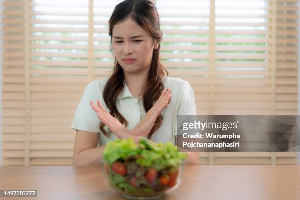 asian women don't like eating green salads, she was bored and didn't like the smell of it. - healthy fats stock pictures, royalty-free photos & images