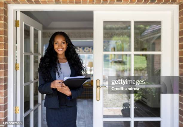 retrato de un agente inmobiliario en la puerta de una casa en venta - agente inmobiliario fotografías e imágenes de stock