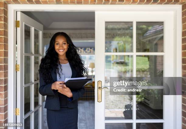 portrait of a real estate agent at the door of a house for sale - real estate agents stock pictures, royalty-free photos & images