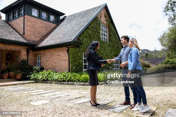 real estate agent meeting a couple for a house showing - landlord stock pictures, royalty-free photos & images