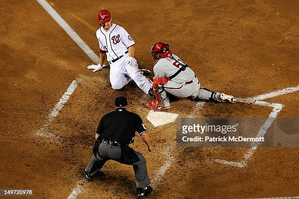 Carlos Ruiz of the Philadelphia Phillies tags Adam LaRoche of the Washington Nationals out at home plate in the sixth inning during a game at...