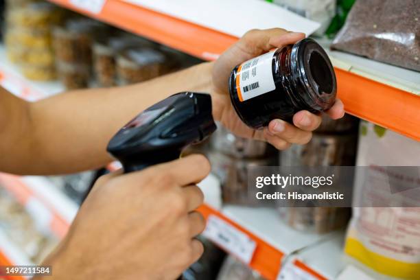 close up of unrecognizable salesperson scanning a product at the supermarket with a barcode scanner - scan barcode stock pictures, royalty-free photos & images