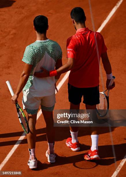 Carlos Alcaraz of Spain appears to be injured as he speaks to Novak Djokovic of Serbia during the Men's Singles Semi Final match on Day Thirteen of...
