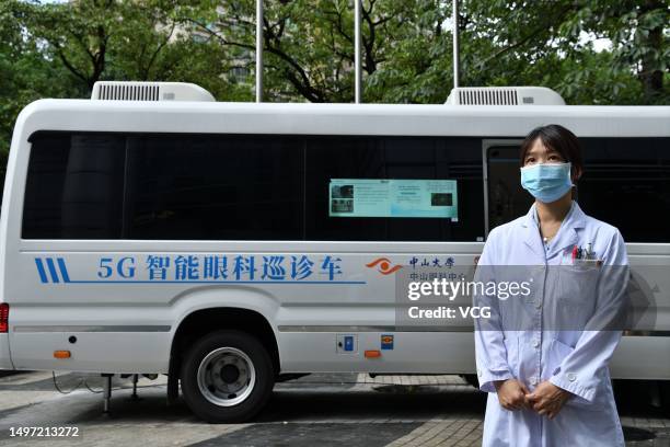 Medical worker from the Zhongshan Ophthalmic Center of Sun Yat-sen University stands aside a 5G intelligent ophthalmic medical vehicle on June 9,...