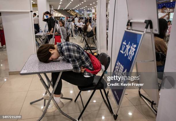 Woman rests on a table at a job fair on June 9, 2023 in Beijing, China. While China’s overall jobless rate is down, youth unemployment in the country...