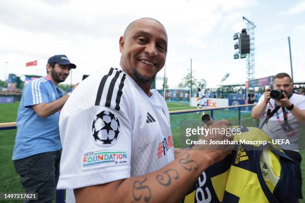 Roberto Carlos signs a Fenerbahce jersey for fans during the Ultimate Champions Match prior to the UEFA Champions League 2022/23 final on June 09,...