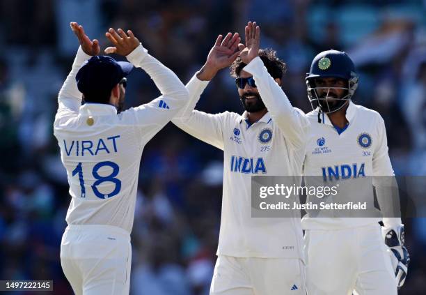 Ravindra Jadeja celebrates with teammate Virat Kohli of India after taking the wicket of Travis Head of Australia during day three of the ICC World...