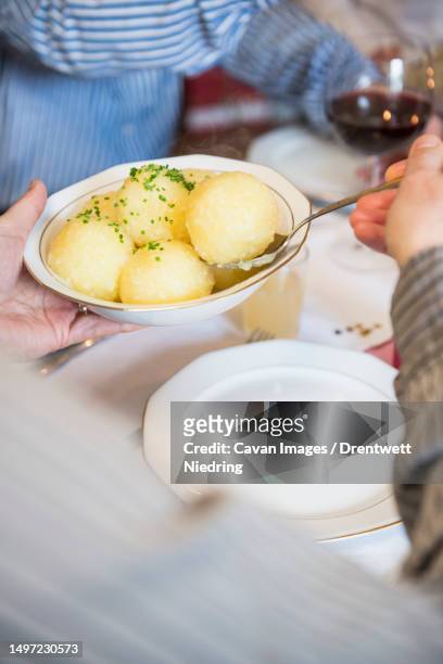 father and son with potato dumplings dish during christmas celebration - teigtaschen stock-fotos und bilder