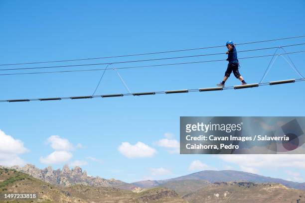 crossing a tibetan bridge during via ferrata climbing in spain - vertigo stock pictures, royalty-free photos & images