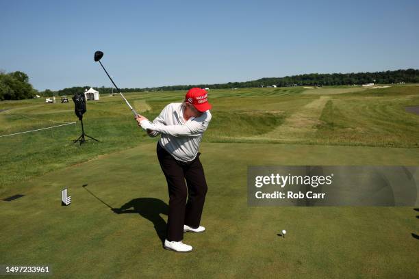 Former US President Donald Trump plays his tee shot on the third hole during the pro-am prior to the LIV Golf Invitational - DC at Trump National...
