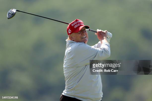 Former US President Donald Trump plays a tee shot during the pro-am prior to the LIV Golf Invitational - DC at Trump National Golf Club on May 25,...