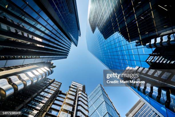 low angle view looking directly up at glass and steel office building in the city of london england uk. - lloyds of london stock pictures, royalty-free photos & images