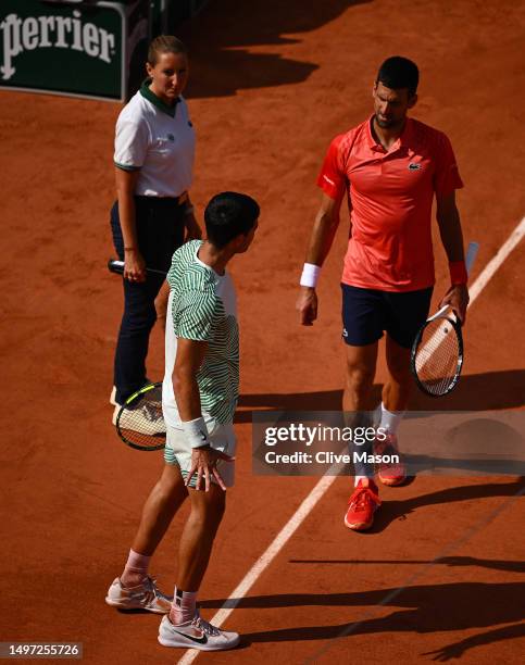 Carlos Alcaraz of Spain appears to be injured as he speaks to Novak Djokovic of Serbia during the Men's Singles Semi Final match on Day Thirteen of...