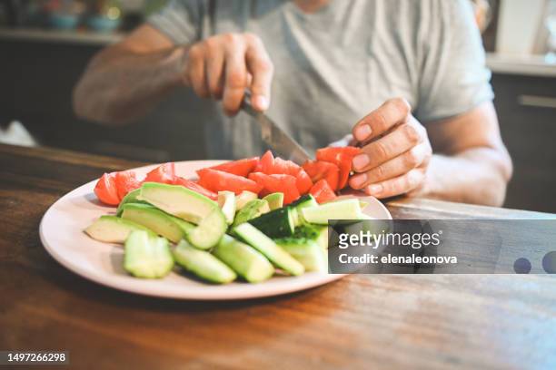 mature adult man eating fresh vegetables and fruits - raw food diet stock pictures, royalty-free photos & images