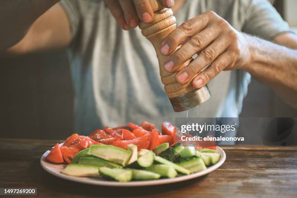 uomo adulto maturo che mangia frutta e verdura fresca - saliera foto e immagini stock