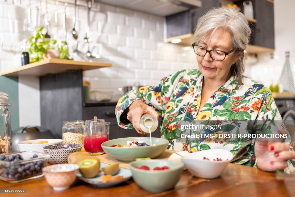 Beautiful senior woman is enjoying her healthy breakfast at home