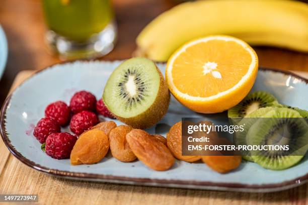 variety of fresh and dried superfood fruits on a plate. - fruta seca fotografías e imágenes de stock