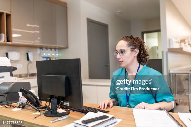 enfermera en la recepción del hospital - operating gown fotografías e imágenes de stock