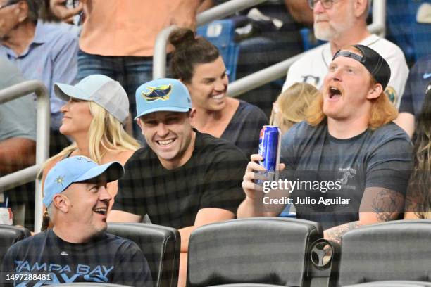 Baker Mayfield and Ko Kieft of the Tampa Bay Buccaneers react during a game between the Tampa Bay Rays and the Texas Rangers at Tropicana Field on...